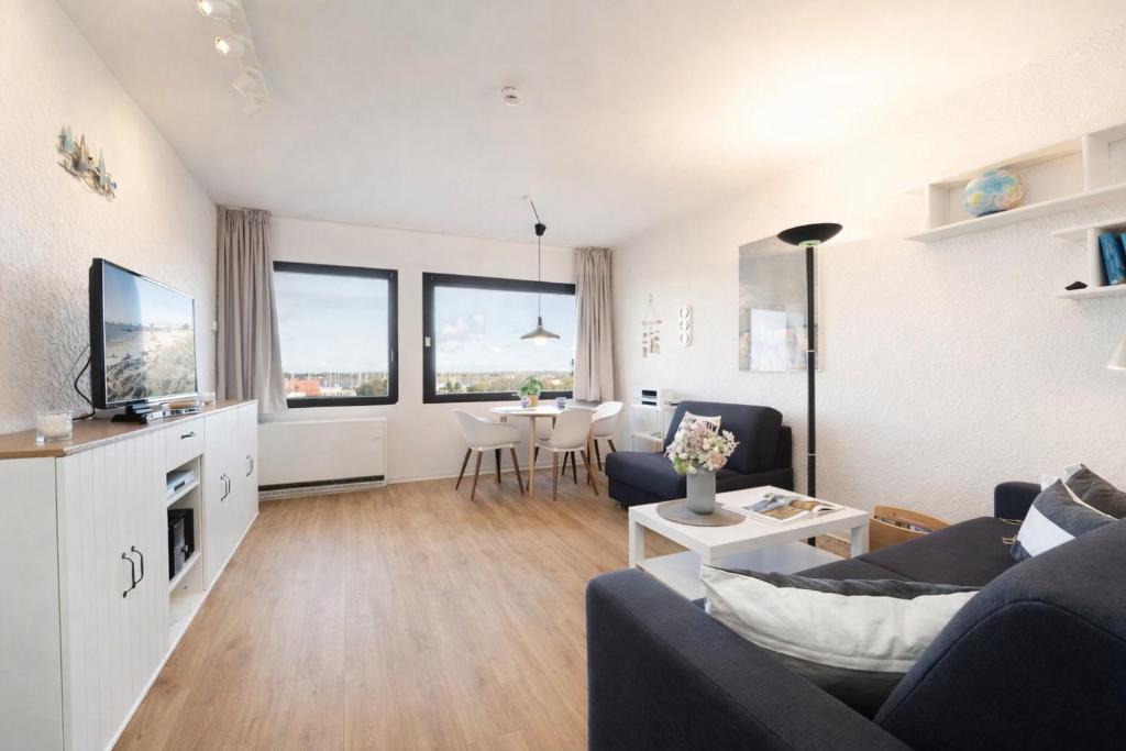 a living room with a couch and a table at Stranddistel 4 Deck 2 in Fehmarn