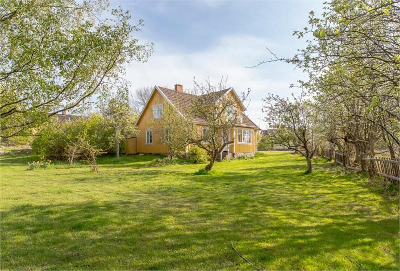 a house with a yard with trees in front of it at Herrgårdsvillan in Tjurkö