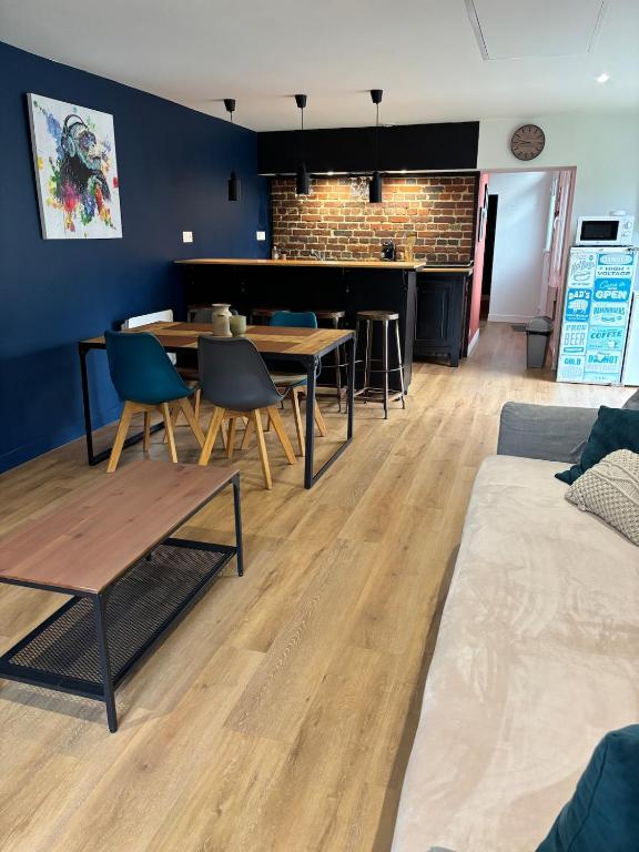a living room with a table and chairs and a piano at La Petite Maison in Arsy