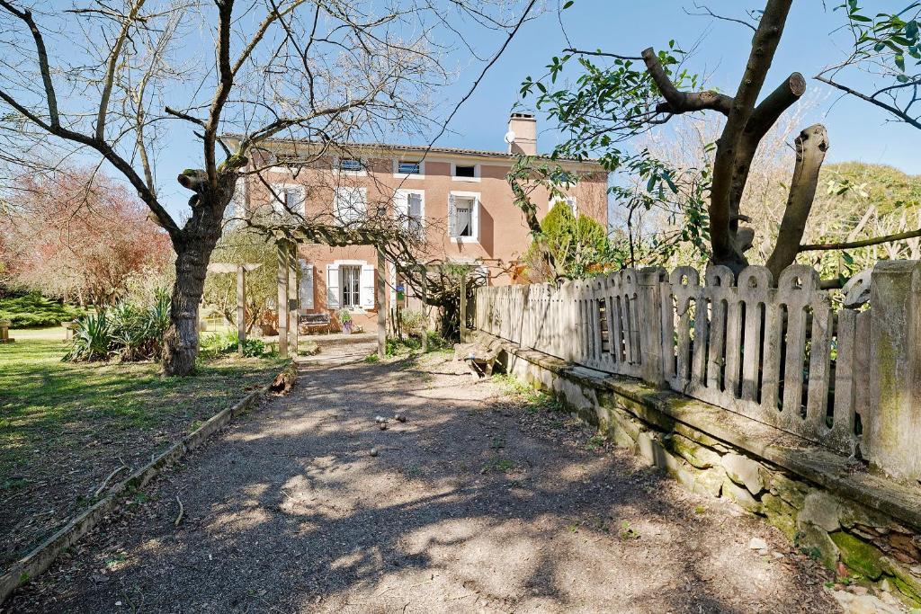 a wooden fence in front of a house at Chambres D'hôtes - Le Marlas in Rieucros