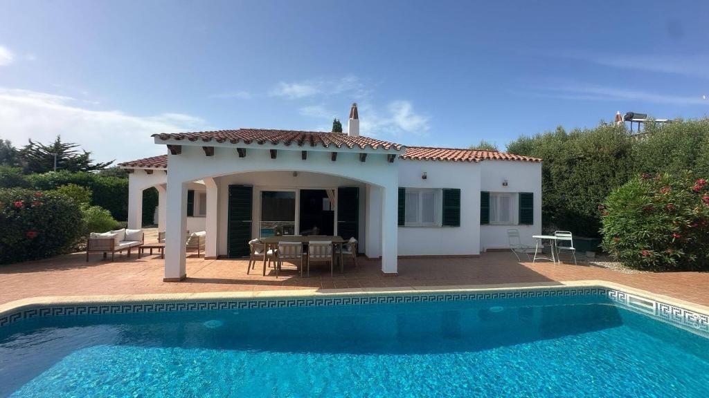a villa with a swimming pool in front of a house at 6 person house with private pool and garden in Trebeluger