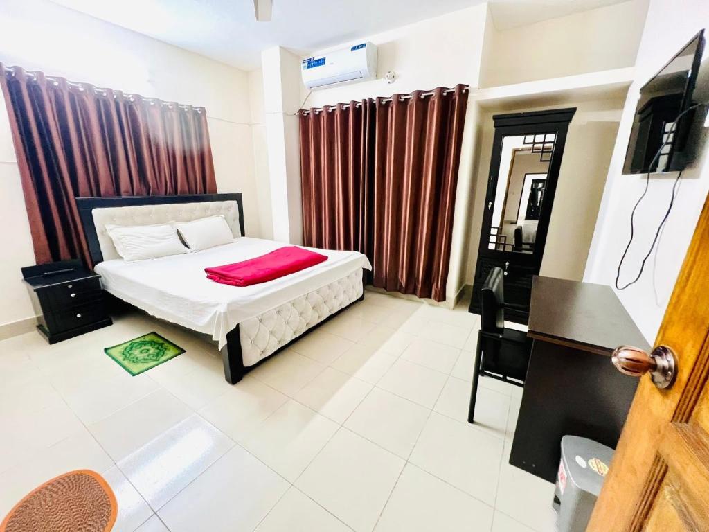 a bedroom with a bed and a television in it at Tourist Home in Ābdullāpur