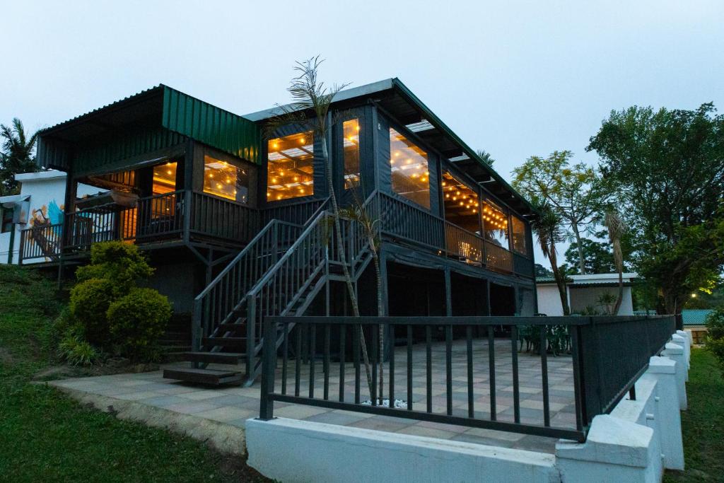 a large glass house with a staircase in front of it at Kingfisher Inn in Pietermaritzburg