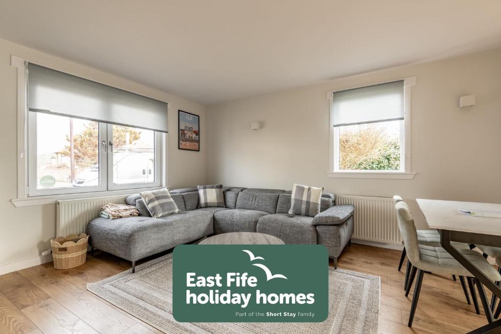 a living room with a couch and a table at Admiralty Lane - No 4 in Elie