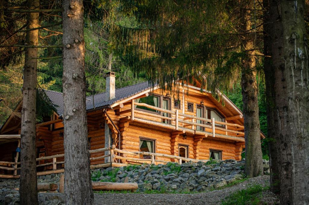 eine Blockhütte im Wald mit Bäumen in der Unterkunft Q Chalet in Săcele