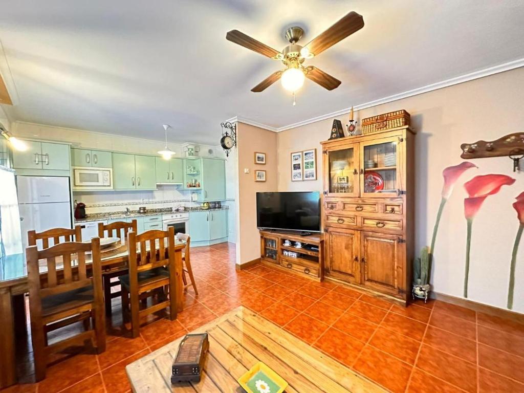 a kitchen with a dining table and a ceiling fan at Apartamento El Rey in Colombres