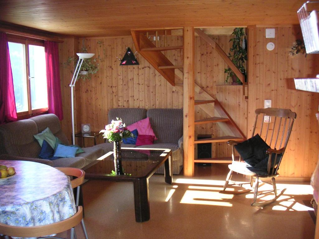a living room with a couch and a spiral staircase at Ferienwohnung Stirnimann-Gemsch in Valzeina