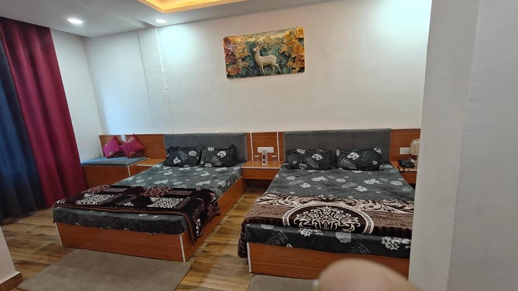 a room with two beds and a painting on the wall at The R B Tower in Unnāo