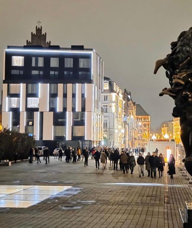 a group of people walking down a city street at Piano Property Rental Wrocław in Wrocław