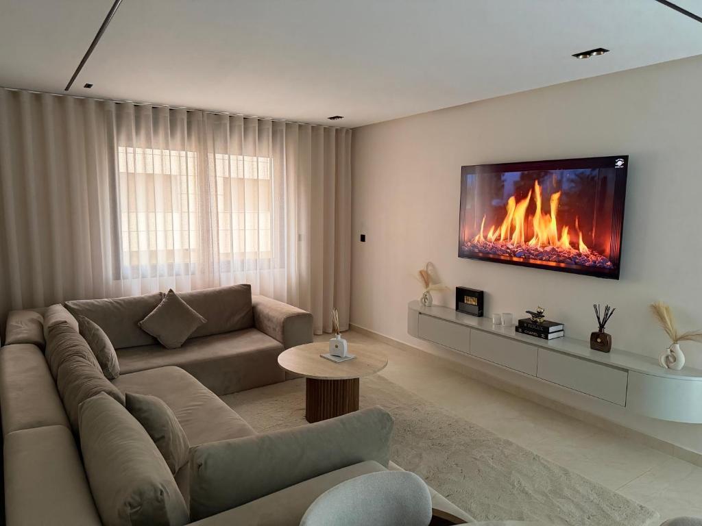 a living room with a couch and a fireplace at Luxe Appartement Haut Standing Nador Lagoon Rif in Nador