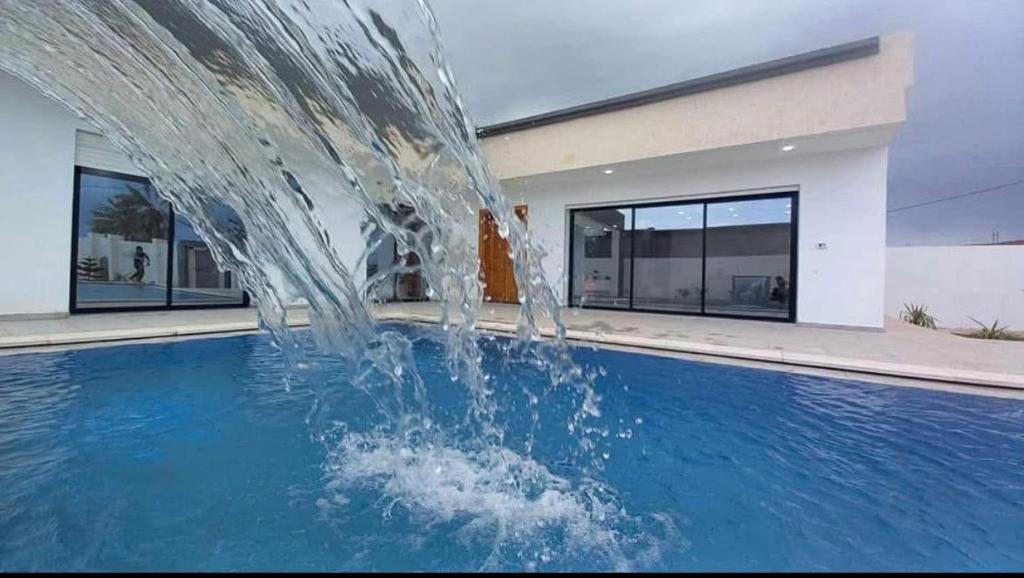 a water fountain in the middle of a swimming pool at Villa Assef in Midoun