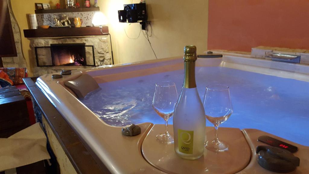 una vasca idromassaggio con 2 bicchieri e una bottiglia di vino di B&B Suite Mirafloris a Pesco Sannita