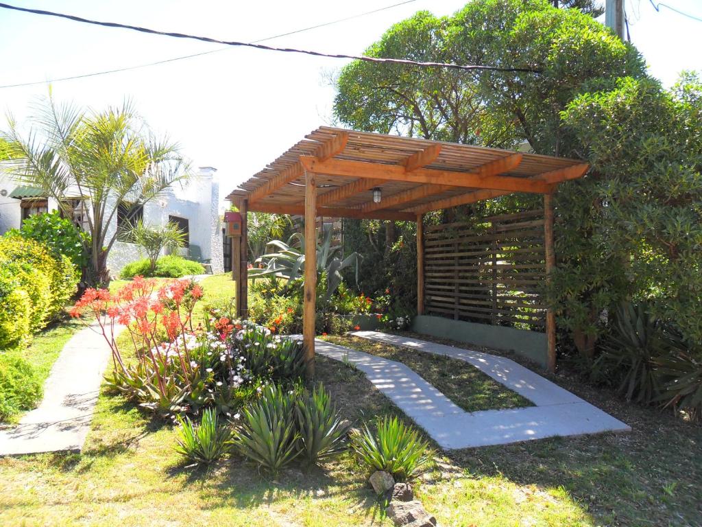 Casa Santa María في لا بالوما: بريغولا خشبي في حديقة بها زهور