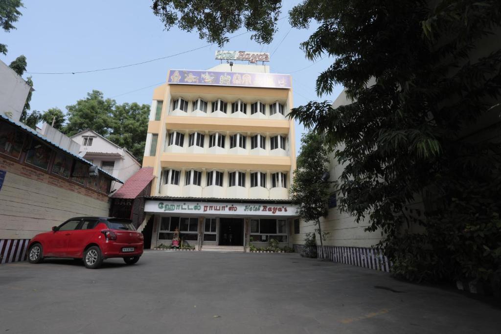 a red car parked in front of a building at Hotel Rayas in Kumbakonam