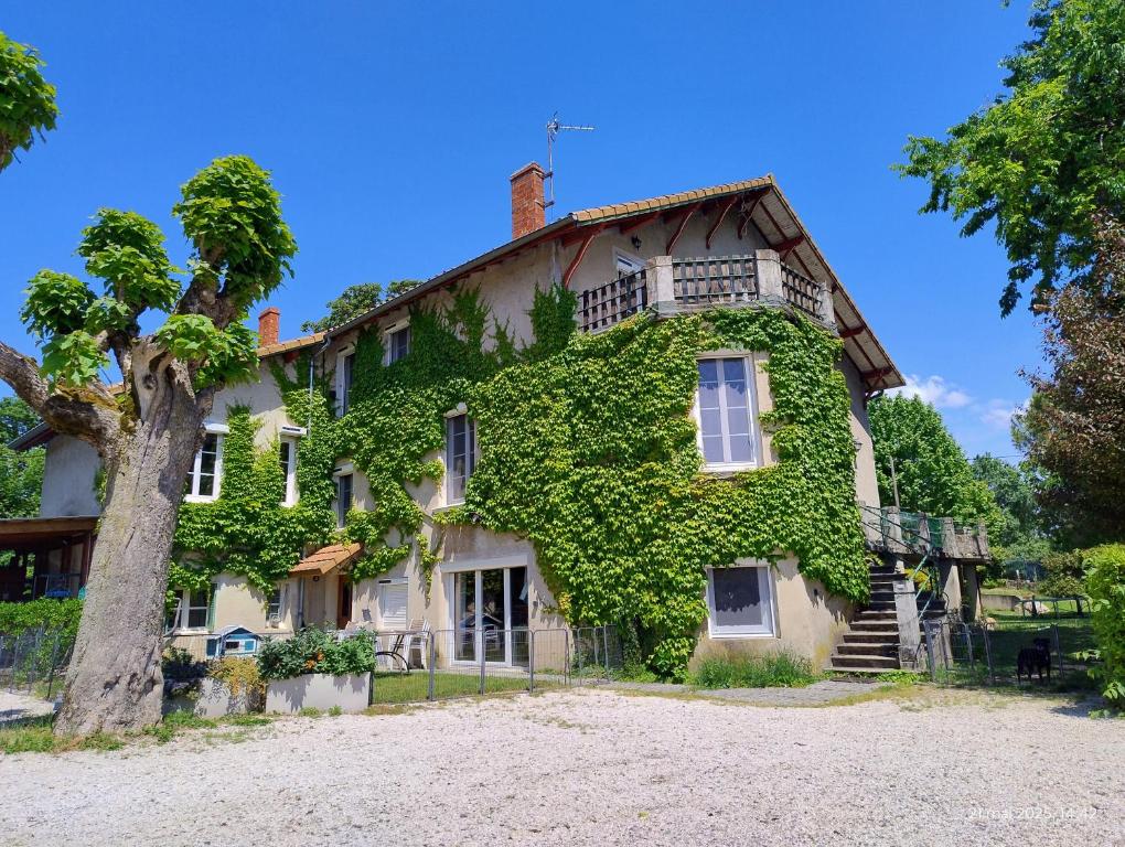 an ivy covered house with a tree at Chambre d'hôtes Park des Collines - Gîte in Génissieux