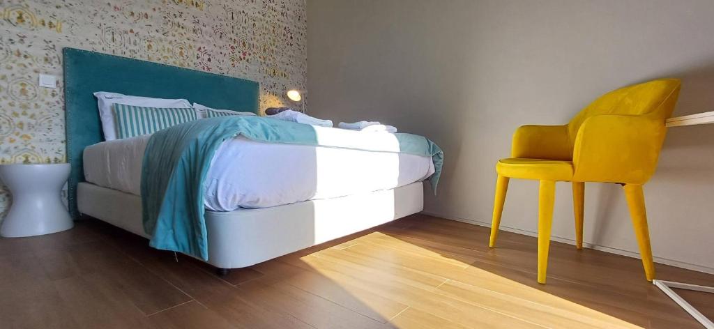a bedroom with a bed and a yellow chair at RestOnDouro Oporto Studio in Valbom