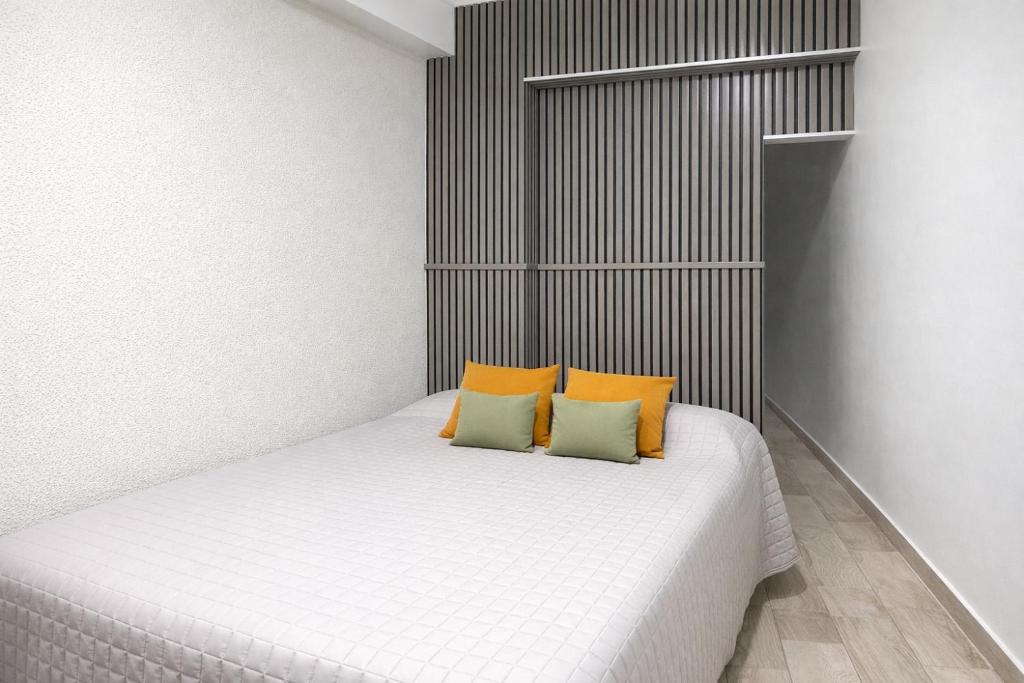 a bedroom with a bed with two pillows on it at Departamento moderno, equipado full en vicente López ,ubicacion inmejorable a 100 metros del tren in Florida