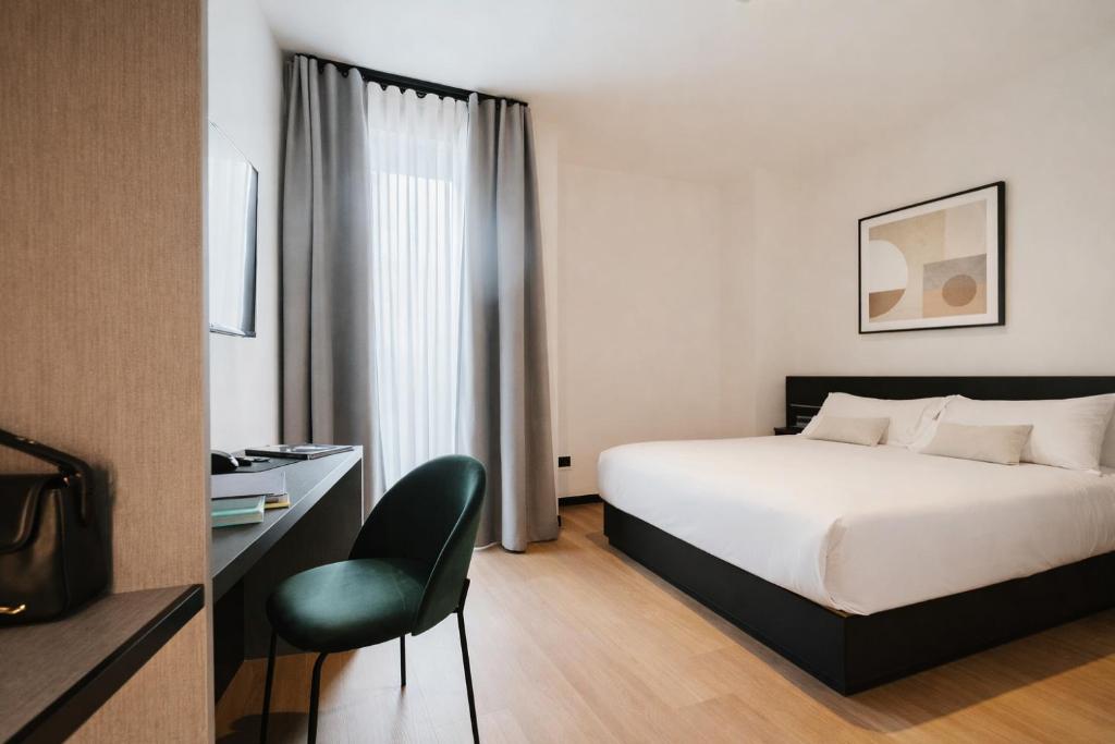 a hotel room with a bed and a chair at Aspio Hotel in Osimo