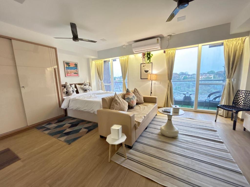 a bedroom with a bed and a large window at Atelier Sol- ultra luxe aparthotel near airport in Pune