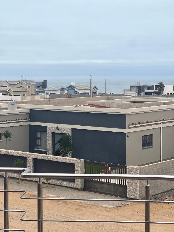a building on the beach with the ocean in the background at EHH Accommodation Hentiesbay in Hentiesbaai
