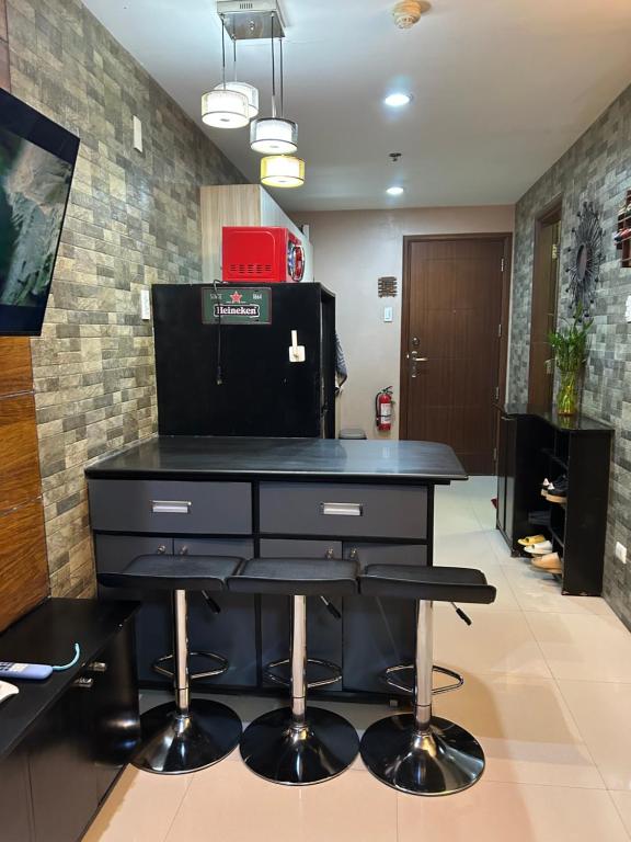 a black desk with two stools in a room at R and RMI CONDOTEL in Baguio