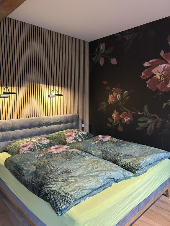 a bed in a bedroom with a floral wallpaper at Hostel Farm Ostedt in Wrestedt