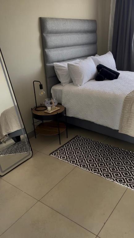 a bedroom with a bed and a table and a laptop at Cubes Ledig Luxury Apartments in Ledig