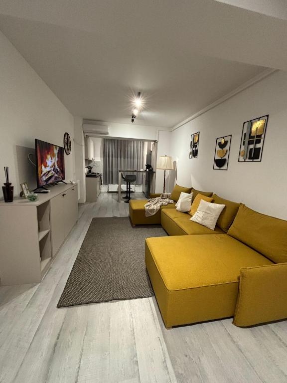 a living room with a yellow couch and a table at The Urban Line by D'or Selection in Bucharest