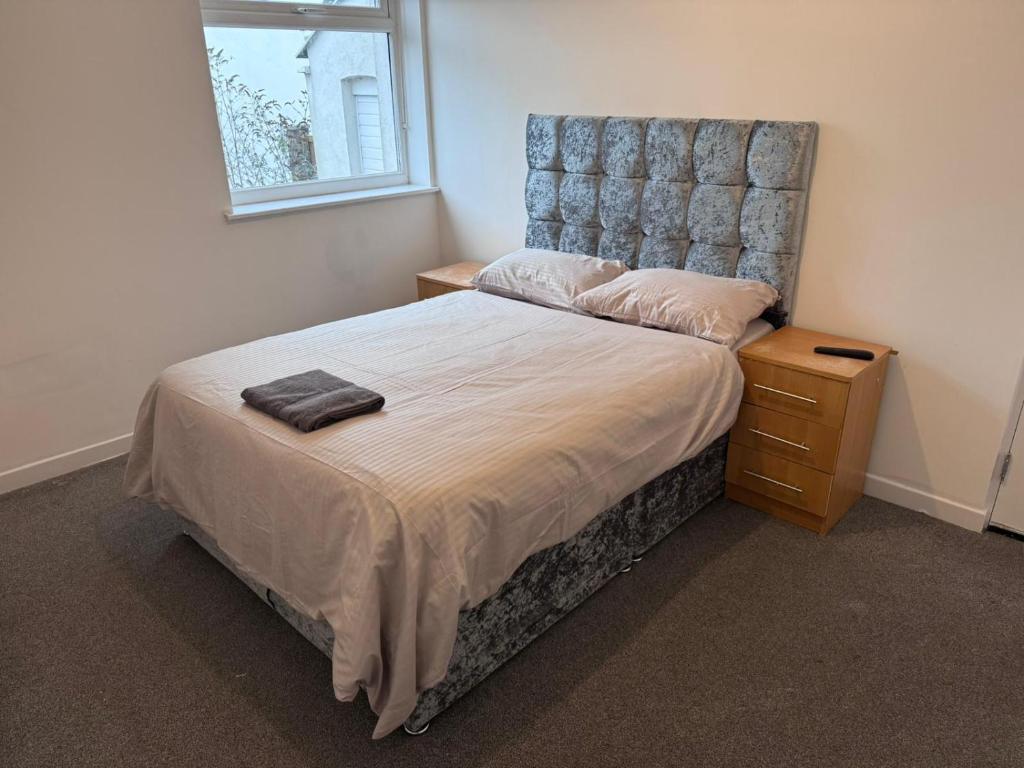 a bedroom with a bed with a headboard and a night stand at King Street Rooms in Liverpool