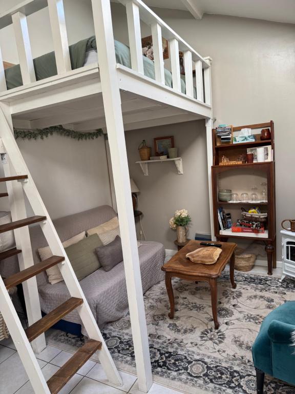a living room with bunk beds and a table at Maisonnette individuelle au coeur de Vernon in Vernon