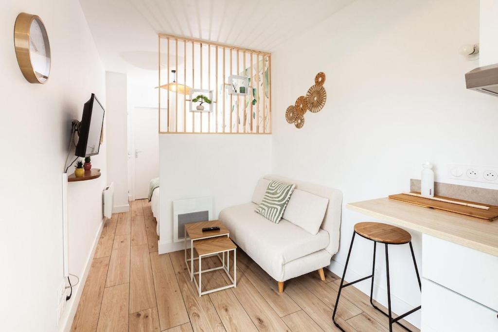 a living room with a white couch and a chair at La casa del Platana in Domagné