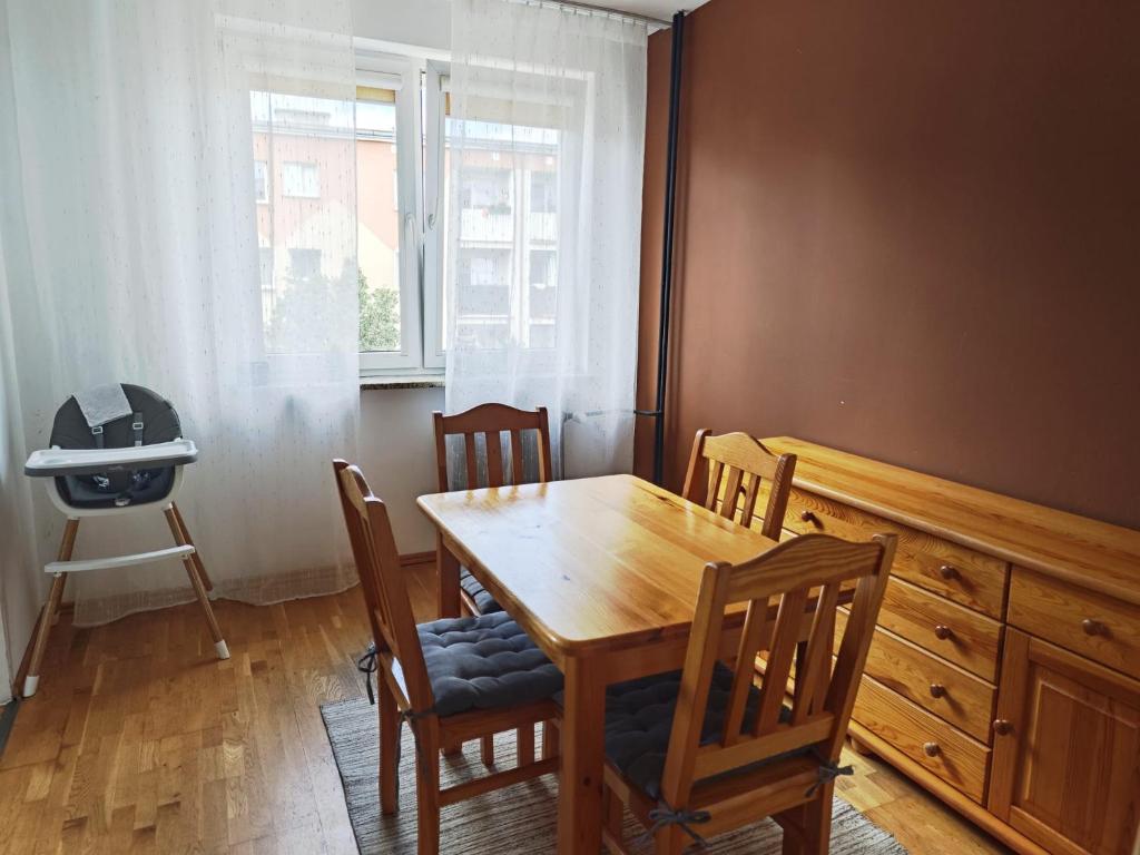 a dining room with a wooden table and chairs at Mieszkanie na Alei in Głogów