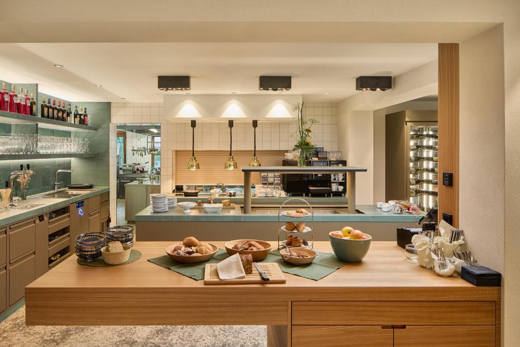 a kitchen with a counter with bowls of fruit on it at OXA - Easy Escape - Bed & Breakfast in Hittisau