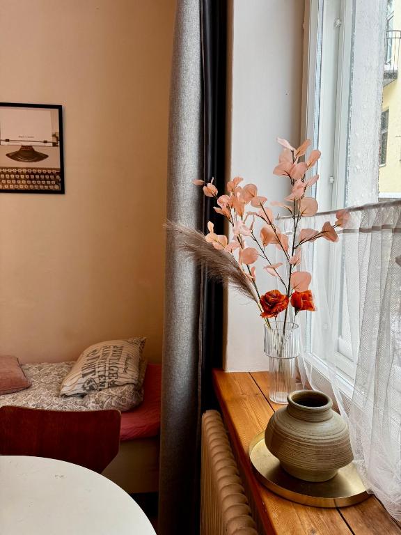a vase with flowers on a table next to a window at Downtown Townhouse! in Helsinki