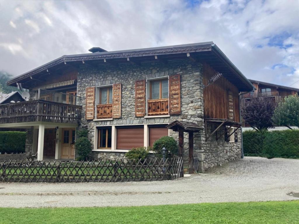 a stone house with a porch and a balcony at Chalet d'Honneur in Chamonix