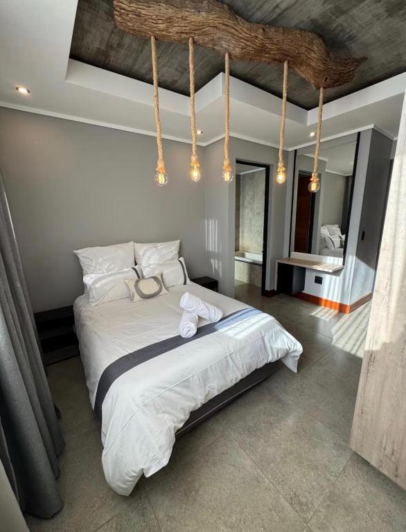 a bedroom with a large bed with white sheets at The Concrete Edit in Benoni