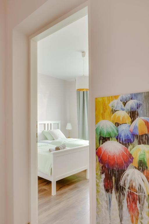 a bedroom with a bed and a painting of umbrellas at Move&Rest Slunj in Slunj