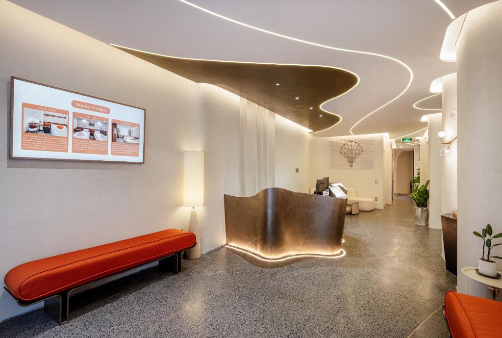 a waiting room with a red bench and a chair at Metrolux By ZG in Ho Chi Minh City