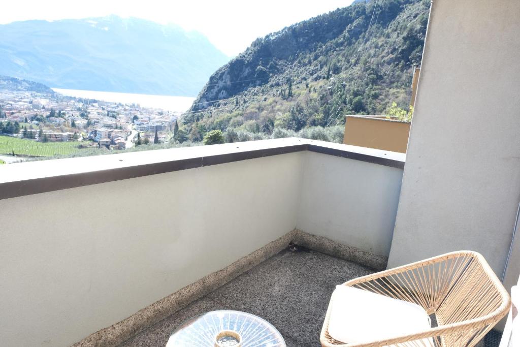 a balcony with a chair and a view of a mountain at Casa Segantini - Panorama Pool Apartment in Riva del Garda