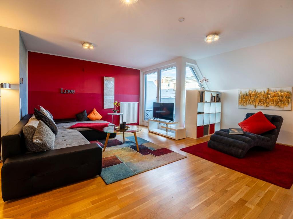 a living room with a black couch and a red wall at Premium Duplex 2BR for 6 with Balcony near City Museums Metro U3 U2 in Vienna