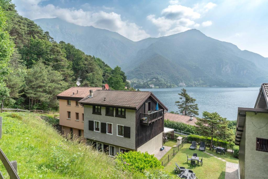 a house on a hill next to a body of water at Casa Maria in Mezzolago