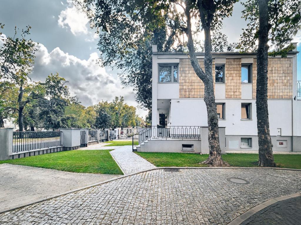 a white building with a tree in front of it at WILla Medica in Poznań