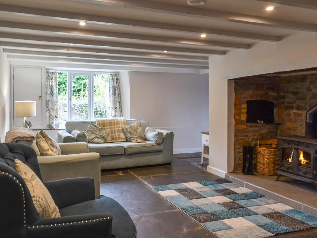 a living room with a couch and a fireplace at Uk47758 - Horseshoe Cottage in Launceston
