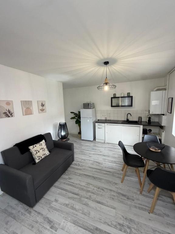 a living room with a couch and a table at Le Thannaron in Bourg-lès-Valence