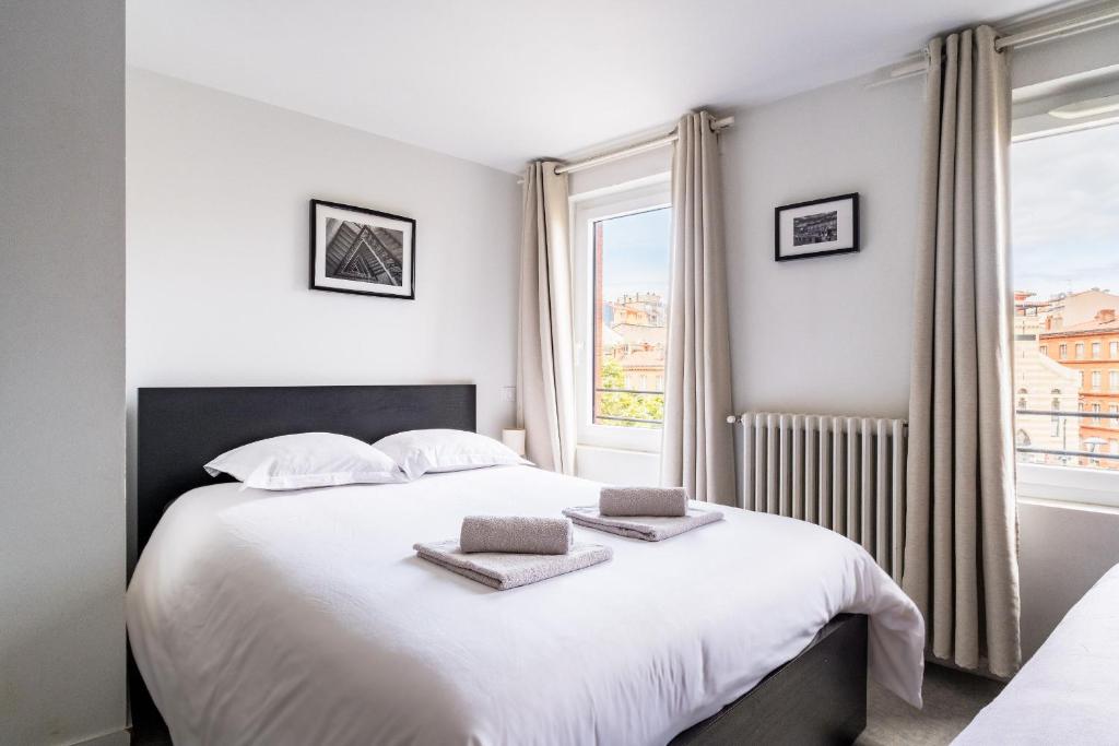 a bedroom with a white bed with two towels on it at Premier Acte - Chambre Spacieuse Sur Les Allées in Toulouse