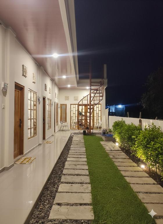 a hallway of a building at night with grass at Anymor Homestay in Komodo Labuan Bajo Airport