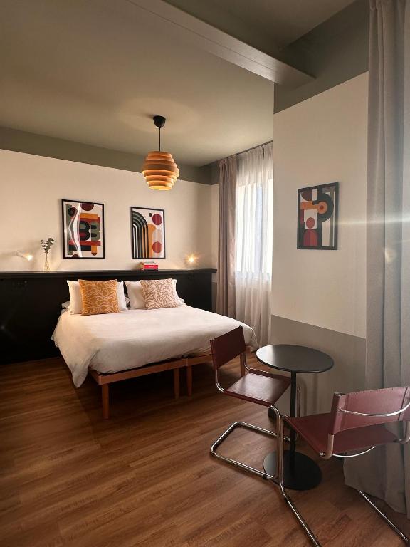 a bedroom with a bed and a table and chairs at Foresteria 33 in Ghedi