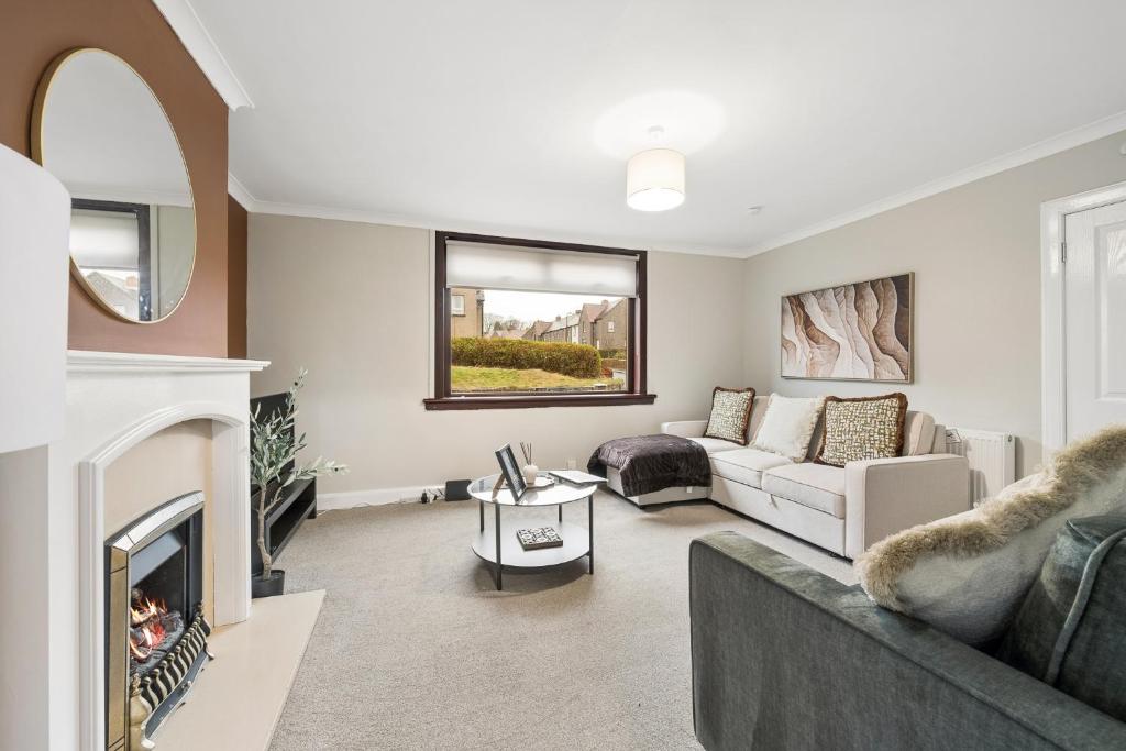 a living room with a couch and a fireplace at Glebe House in Uphall