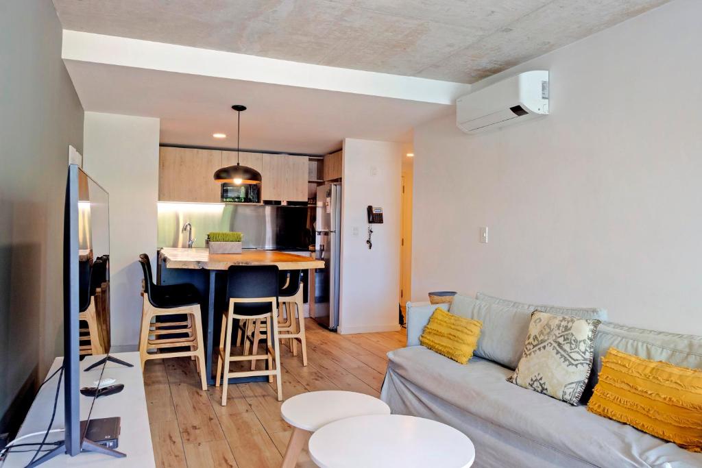 a living room with a couch and a kitchen at Oceana Suites Mansa Inn in Punta del Este