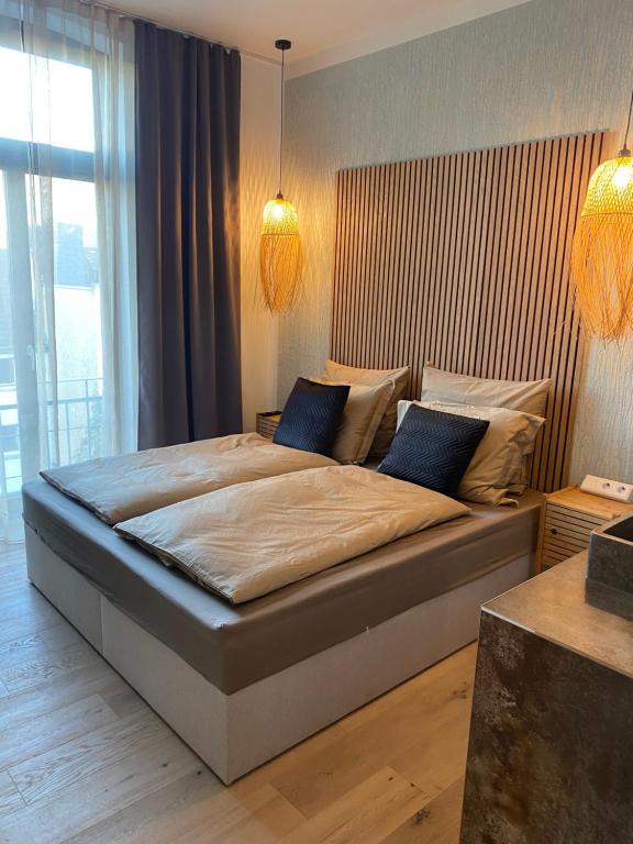 a bedroom with a large bed with blue pillows at H-36 RESIDENCE - BRIGHT Collection in Koblenz